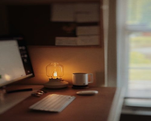 cozy home office desk beside a window with soft daylight